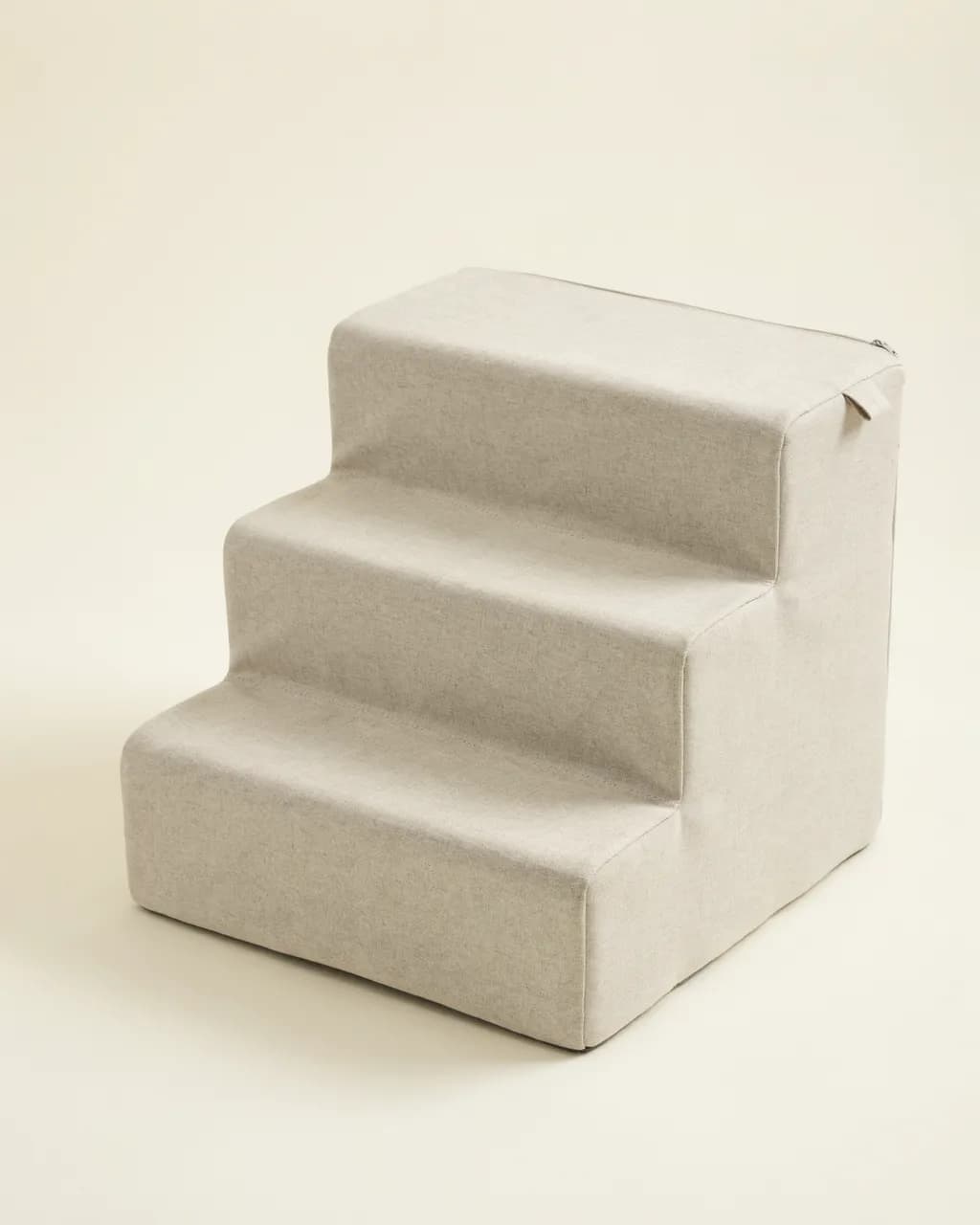 Escalier en mousse beige à trois marches, vue de face sur ses marches larges et sa housse en tissu doux
